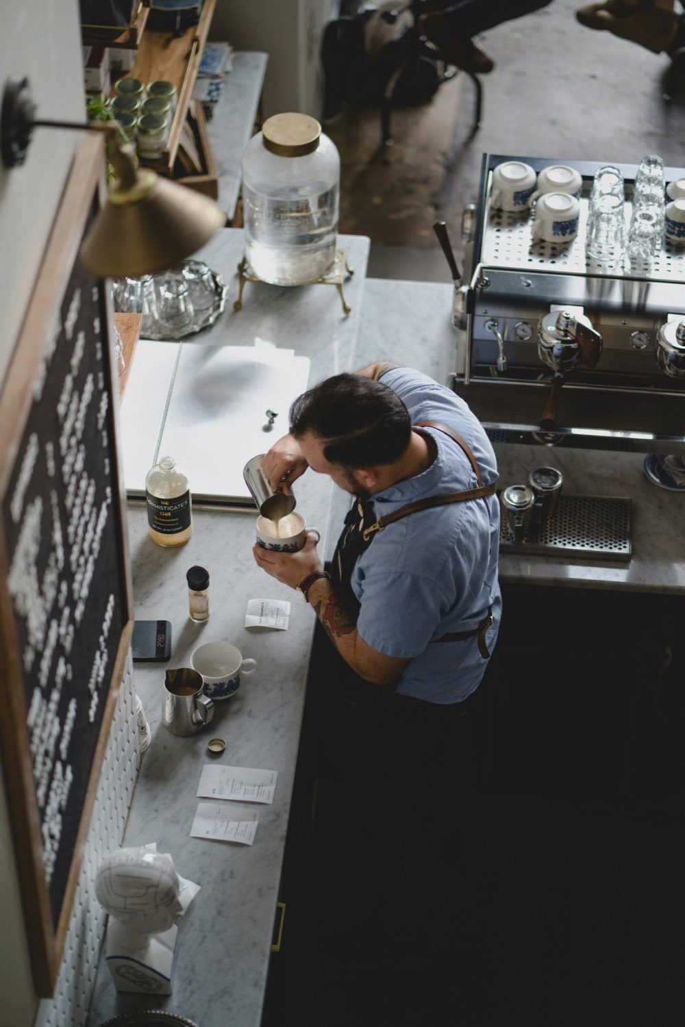 A barista pouring at a specialty coffee counter